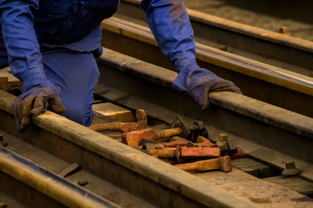 Mains gantées d'un ouvrier ferroviaire au travail, formation SECUFER Toulouse